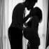 man standing near window kissing woman