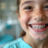 Adolescent souriant avec appareils dentaires en cabinet dentaire